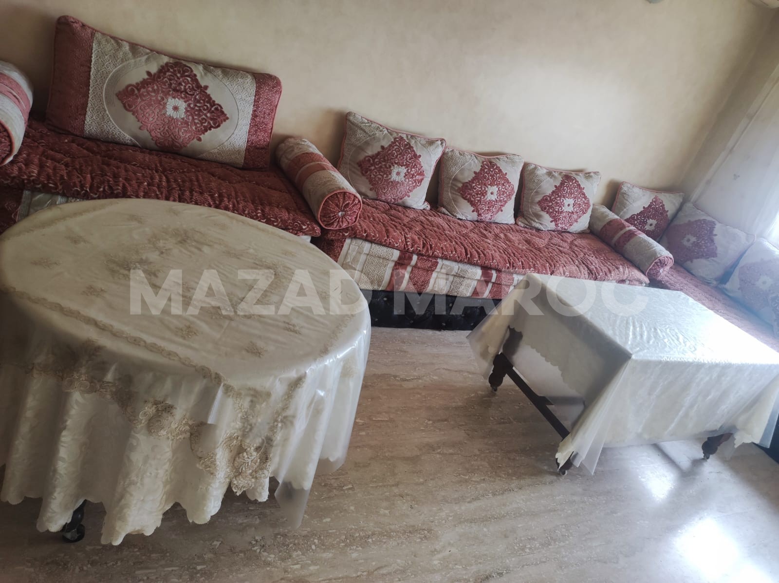 Salon marocain avec 2 tables et un meuble de rangement